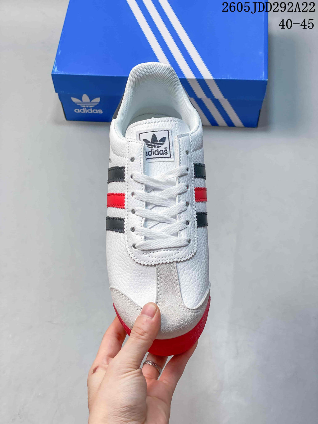Top view of the white adidas Samoa sneaker showing the lace-up front, tongue branding, and red outsole edge.