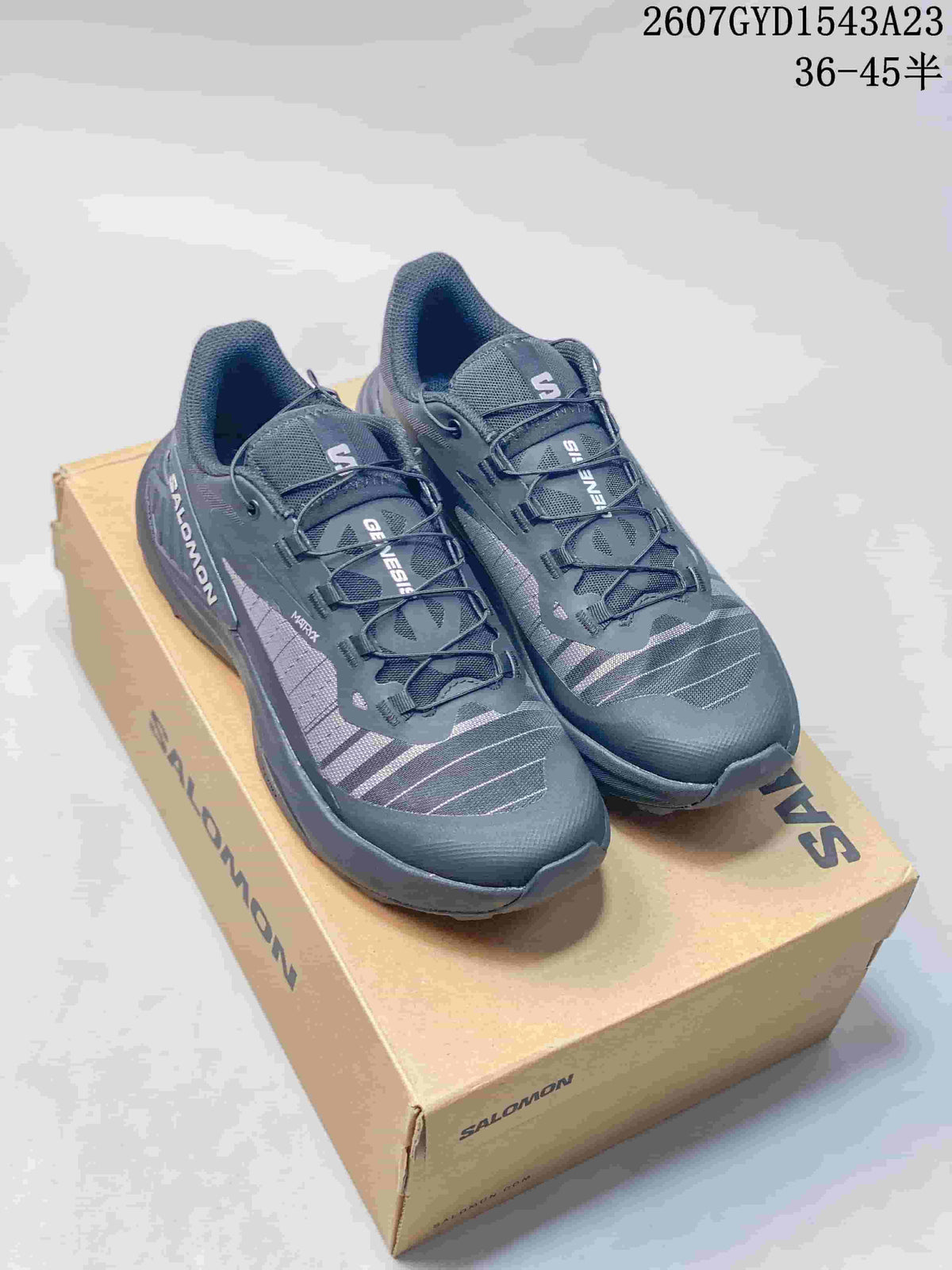 Pair of dark gray and black Salomon Genesis trail running shoes displayed on a Salomon shoe box; image text shows style code 2607GYD1543A23 and size range 36–45.5.