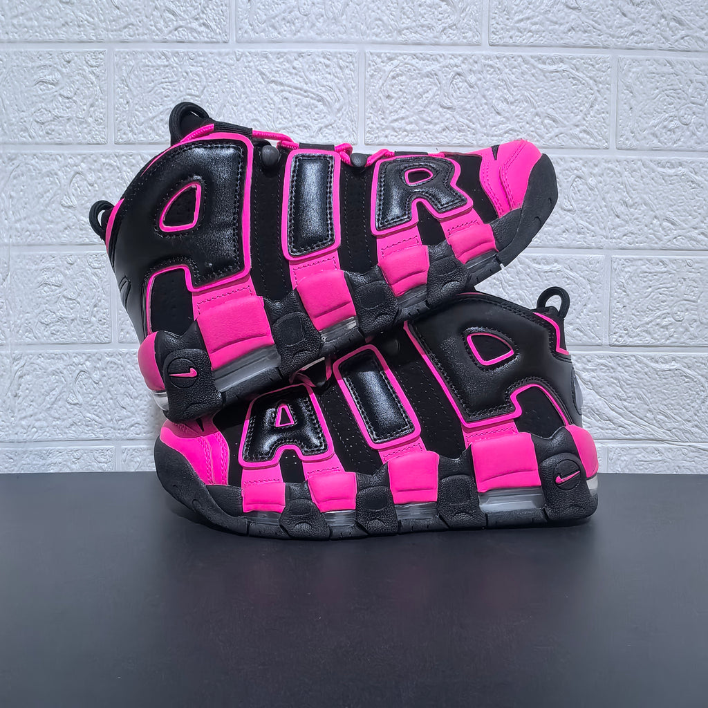 Pair of black and pink Nike Air More Uptempo sneakers shown from the side