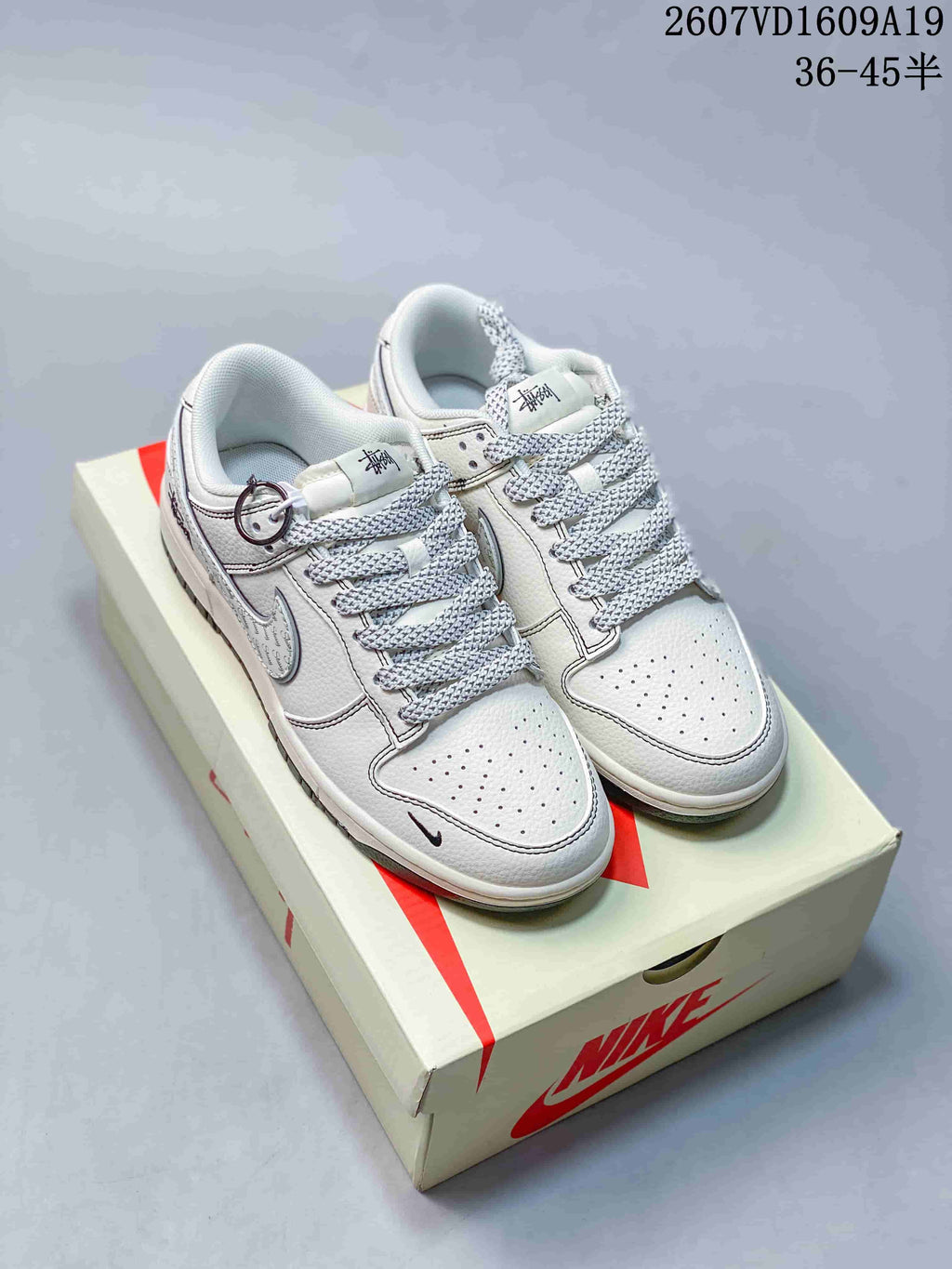 Pair of white and navy low-top sneakers displayed on a Nike-branded box; the image shows style code 2607VD1609A19 and size range 36–45.