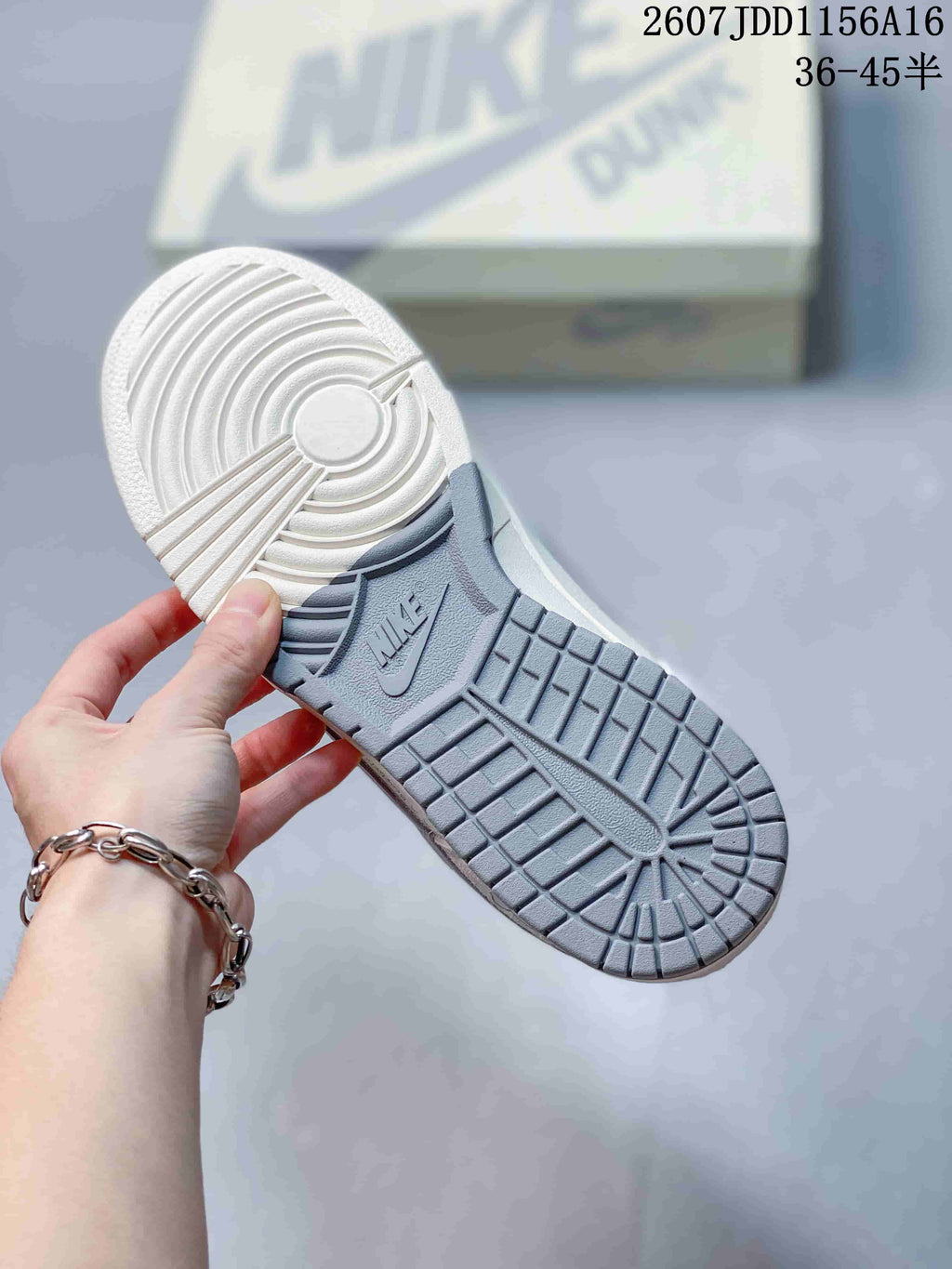 Close view of the grey rubber outsole showing circular and geometric traction details with Nike branding.