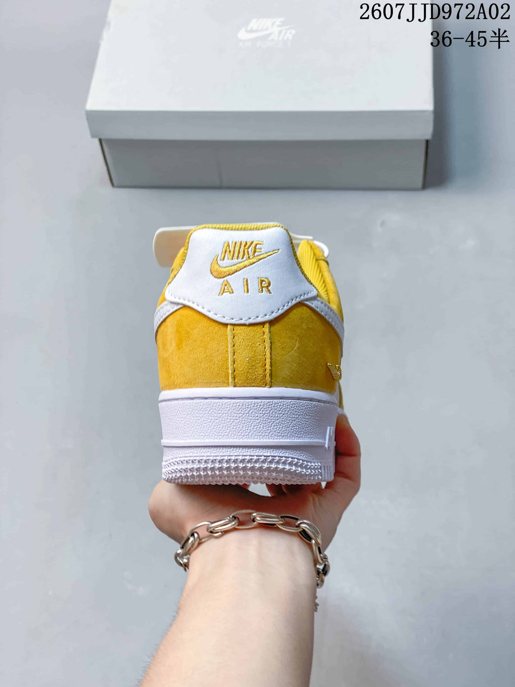 Rear view of a yellow and white Nike Air Force 1 low-top sneaker with embroidered heel branding.