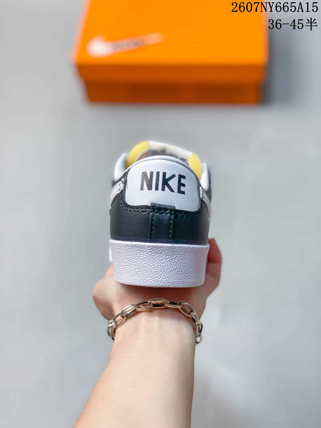 Rear view of the sneaker showing black heel panels, white midsoles, and Nike branding.