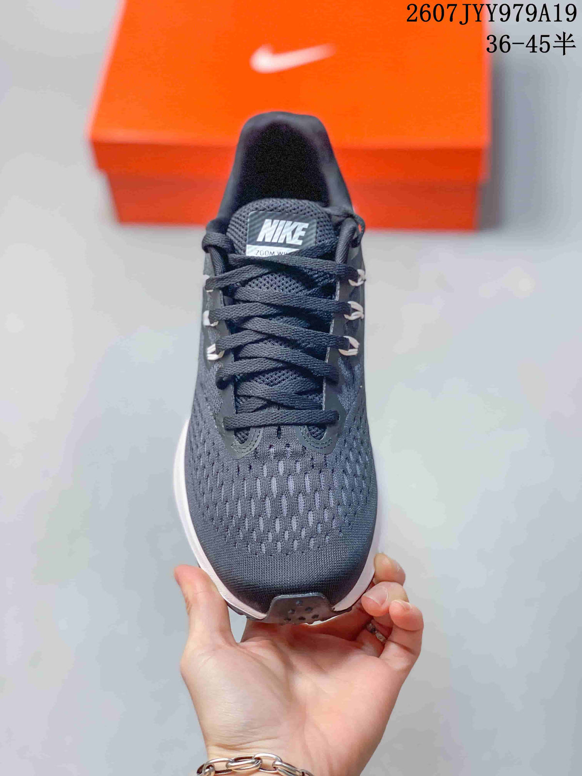 Top view showing the lace-up dark gray upper, patterned forefoot, and Nike tongue label.