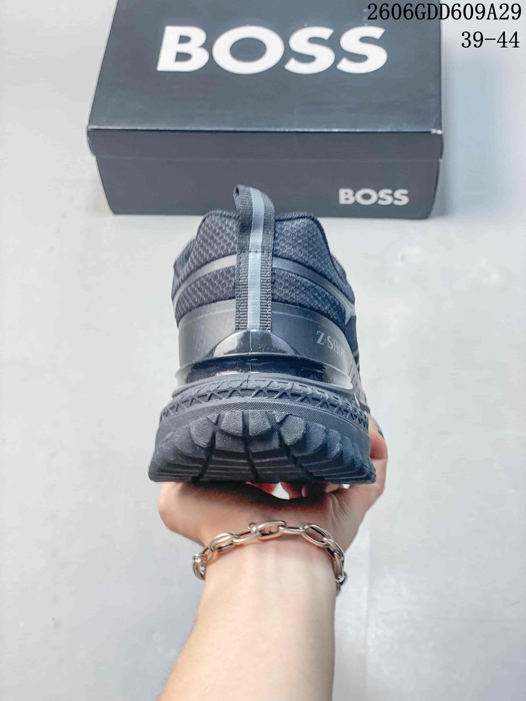 Rear view of a gray sneaker highlighting the heel pull tab and lugged outsole.