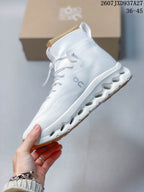 Side view of the white high-top sneaker showing the lace system, collar, side branding, and open-channel sole structure.