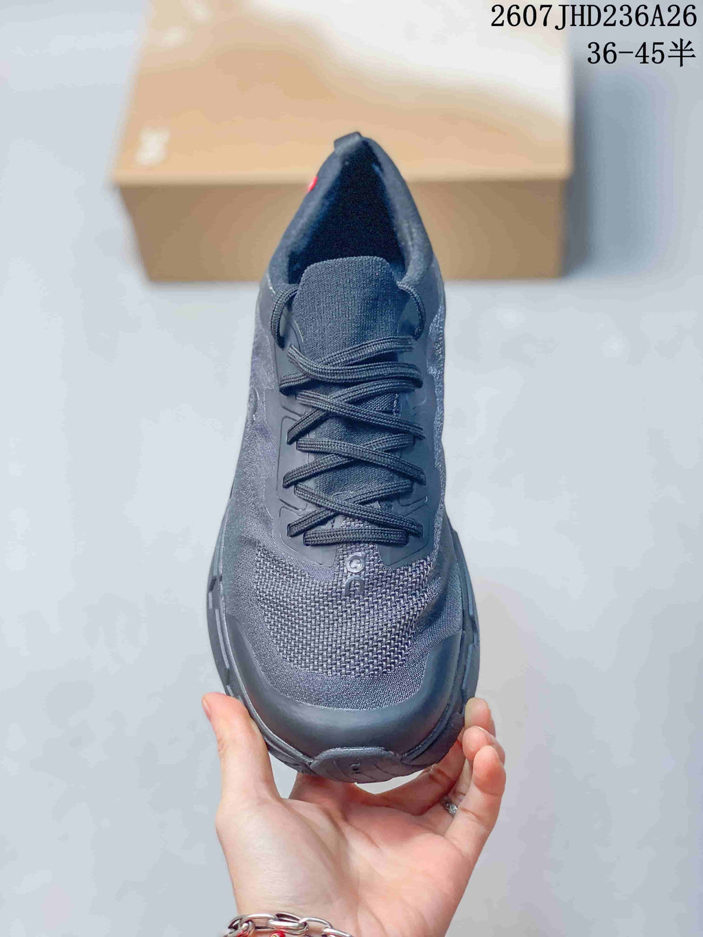 Top view of a dark gray lace-up running shoe showing the textured toe area and tongue; overlay text shows 2607JHD236A26 and 36–45.5.