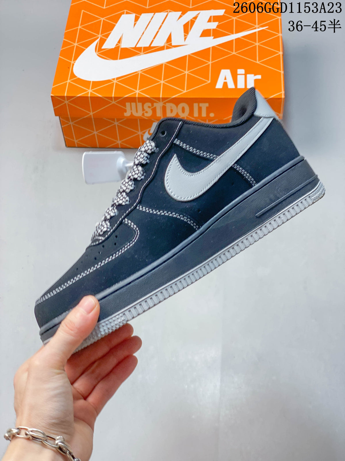 Side view showing gray Swoosh panels, dark navy upper, and patterned laces