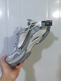 Close-up view of gradient grey Balenciaga sneakers showing the layered upper, mesh panels, dark accents, and chunky sole.