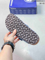 Close view of the patterned outsole on the blue clog sandal, with a Birkenstock-branded box in the background.