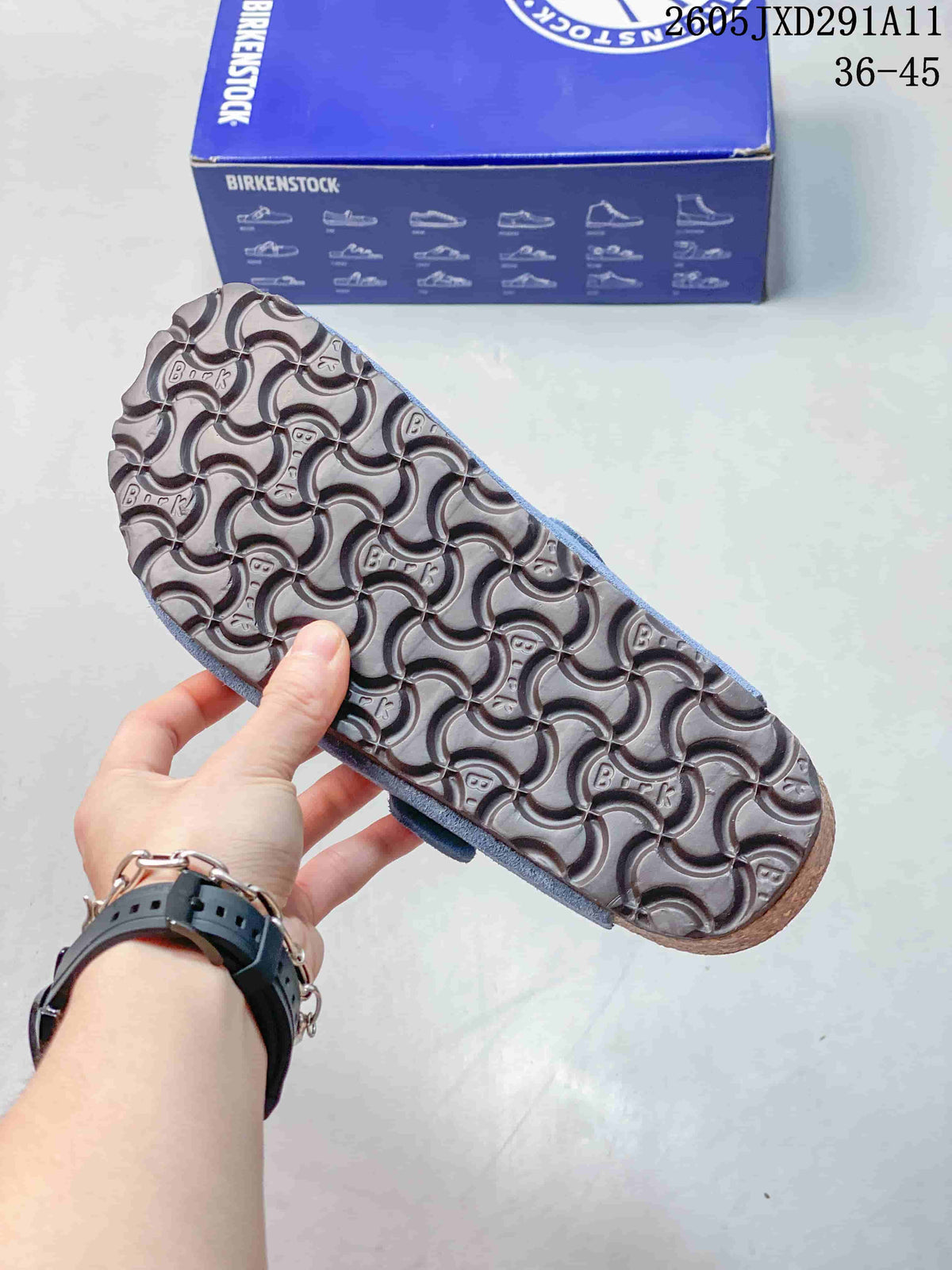 Close view of the patterned outsole on the blue clog sandal, with a Birkenstock-branded box in the background.