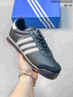 Dark Adidas Samoa sneaker with white side stripes and a contrasting multicolor outsole.