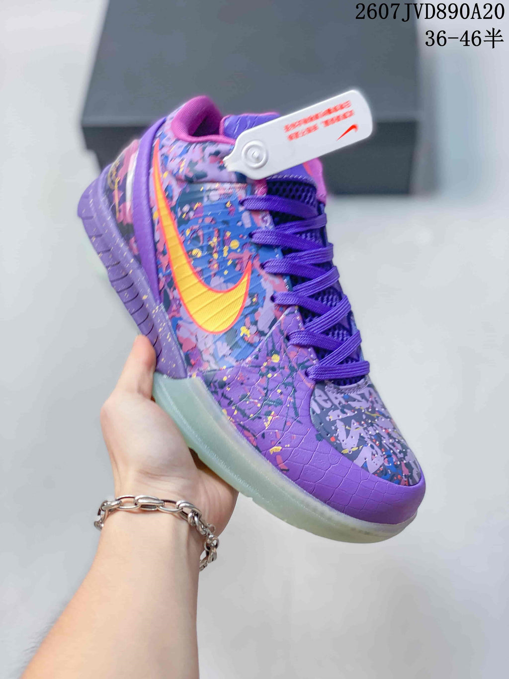 Angled side view of the purple Nike basketball shoe showing the yellow-orange Swoosh, patterned upper and translucent outsole.