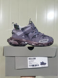 Lavender Balenciaga Track sneaker displayed on a shoebox, showing the side profile, layered panels, mesh sections, dark sculpted outsole, and box label.
