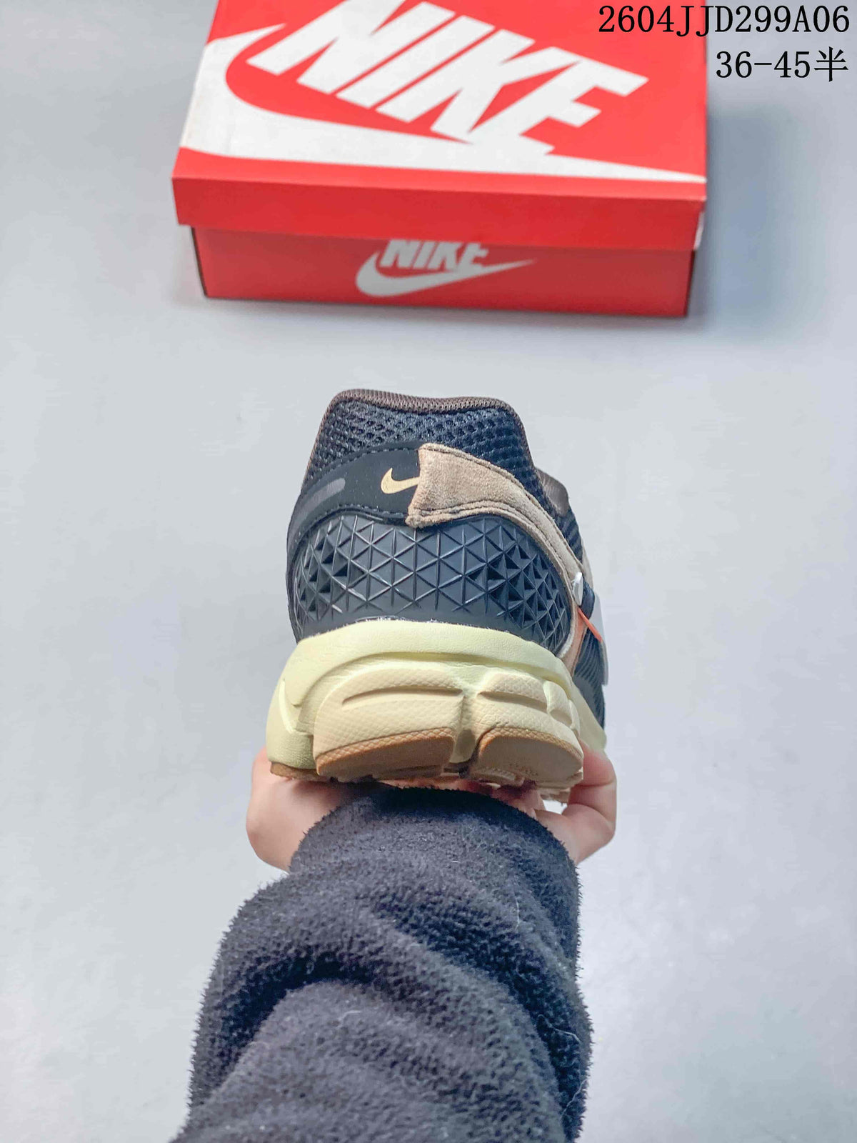 Rear view of the navy sneaker showing the textured heel panel, small Swoosh detail, and off-white midsole.