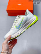 Side view of the light-colored sneaker showing the swoosh, sculpted white midsole, and bright lime outsole accent.