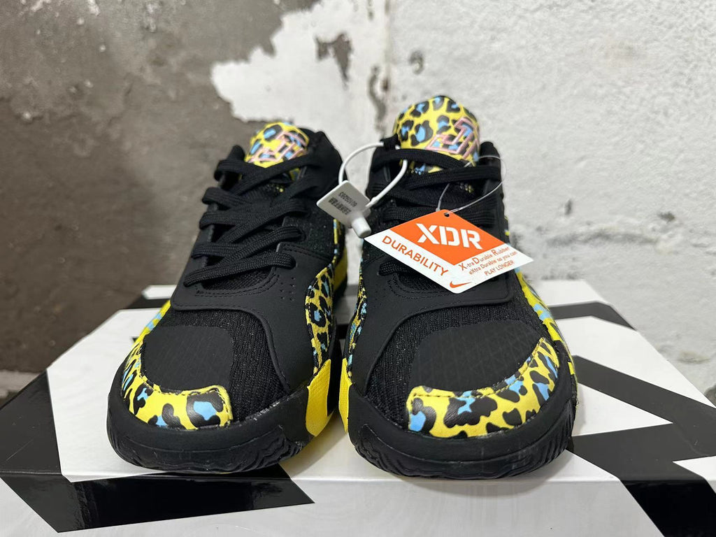 Front view of black Jordan Luka 1 shoes with yellow and blue patterned overlays and black laces