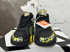 Front view of black Jordan Luka 1 shoes with yellow and blue patterned overlays and black laces