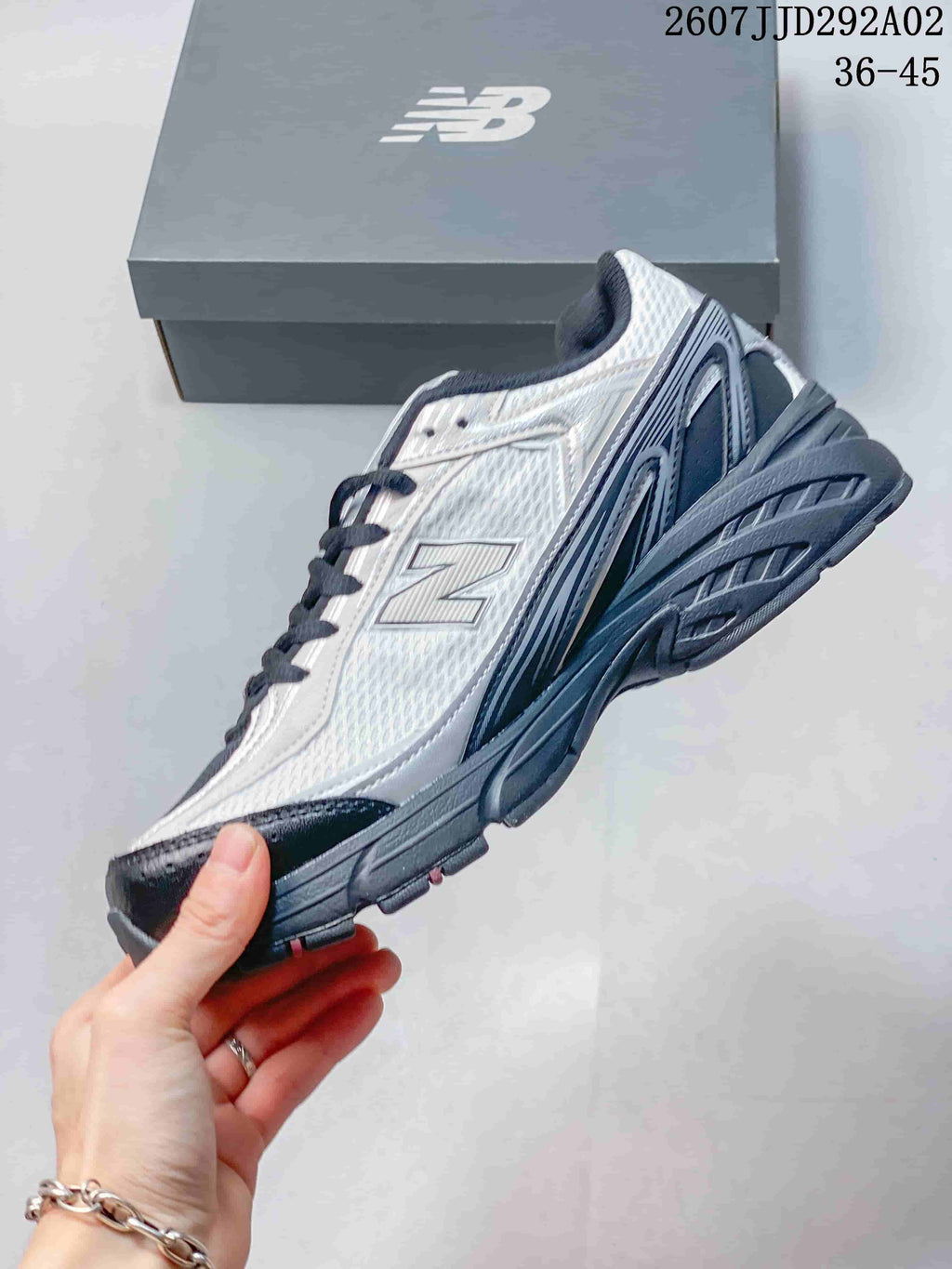 Side view highlighting the mesh-style upper, layered panels, New Balance branding, and textured sole.