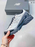 Side view highlighting the mesh-style upper, layered panels, New Balance branding, and textured sole.