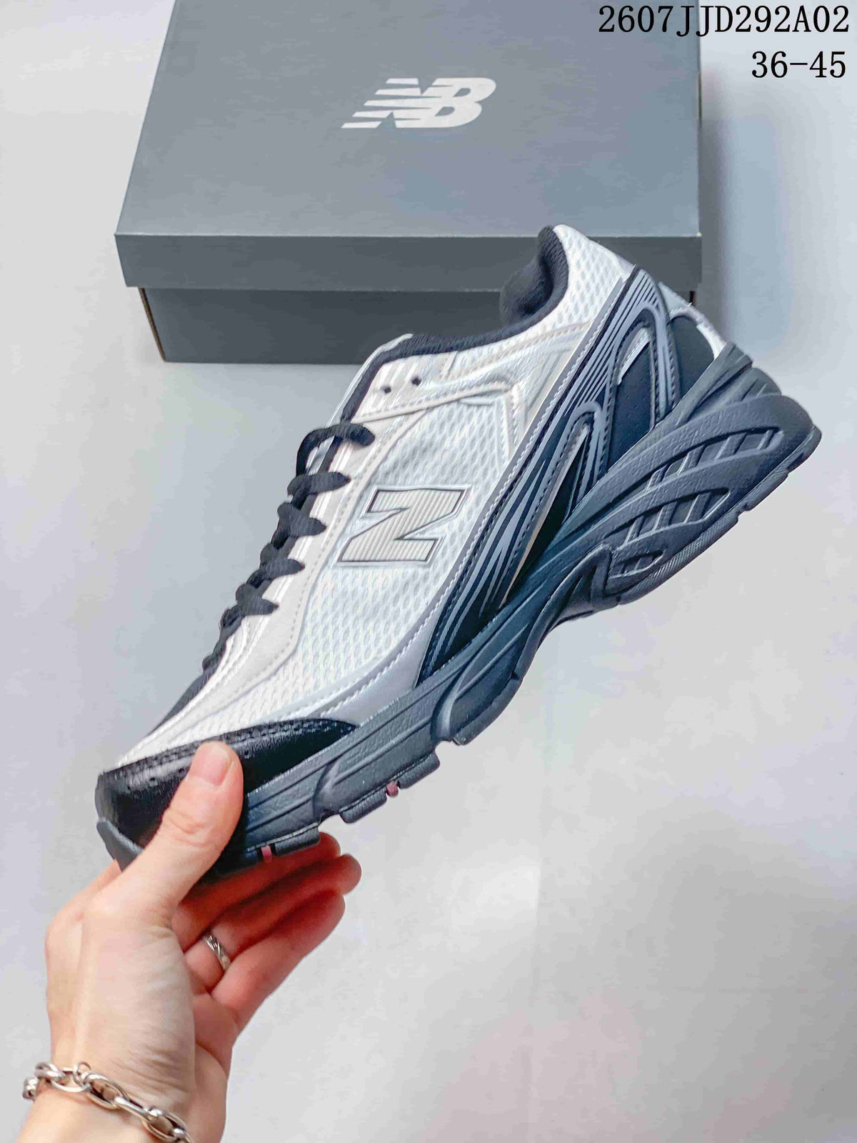 Side view highlighting the mesh-style upper, layered panels, New Balance branding, and textured sole.