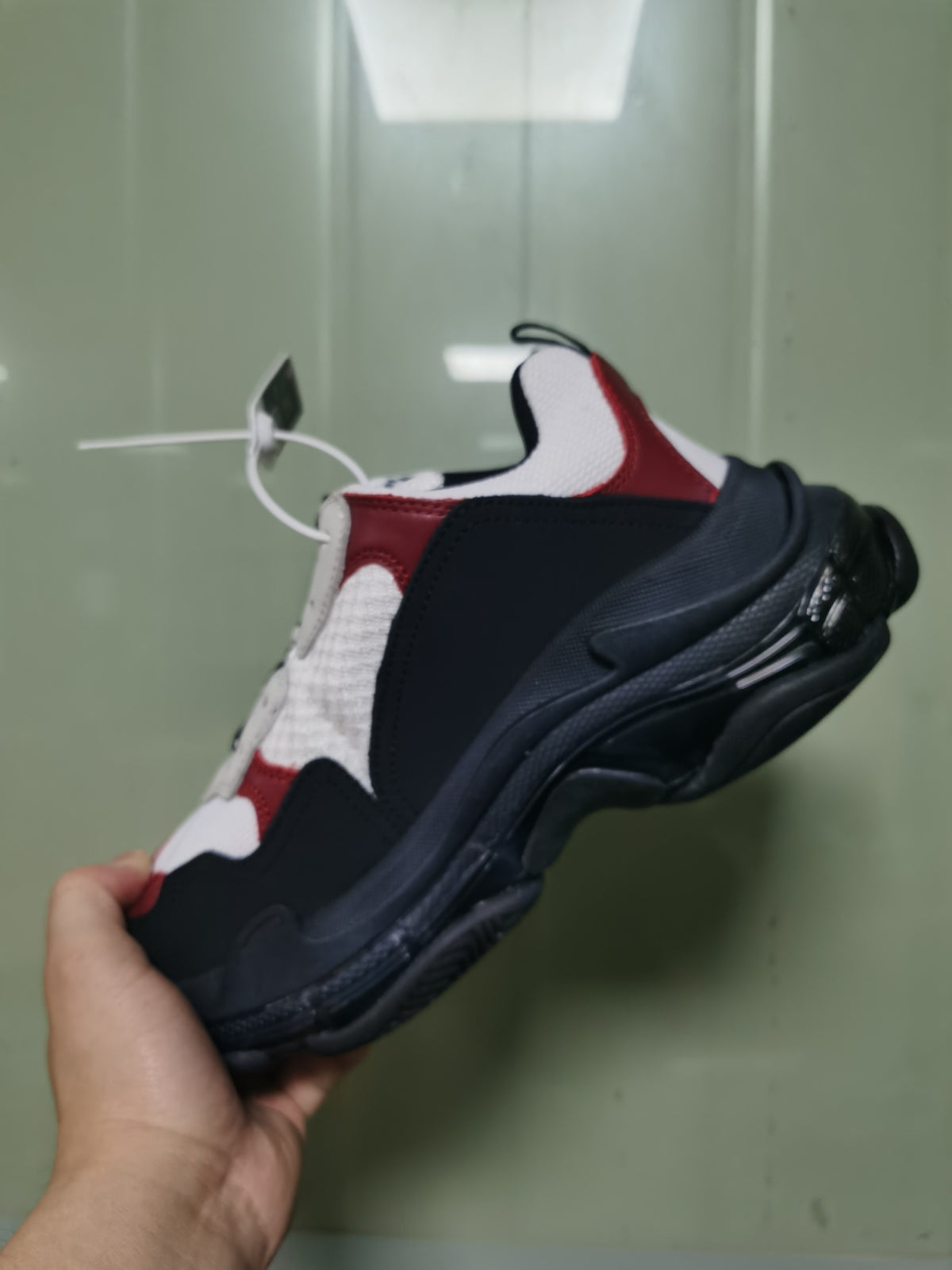 Rear-side view showing the layered heel structure, dark outsole and burgundy-white upper details.