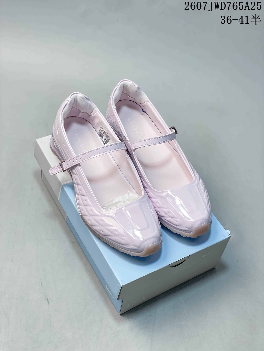 Pair of pearl pink Nike Shox Z Calistra Mary Jane-style sneakers shown on a shoebox.