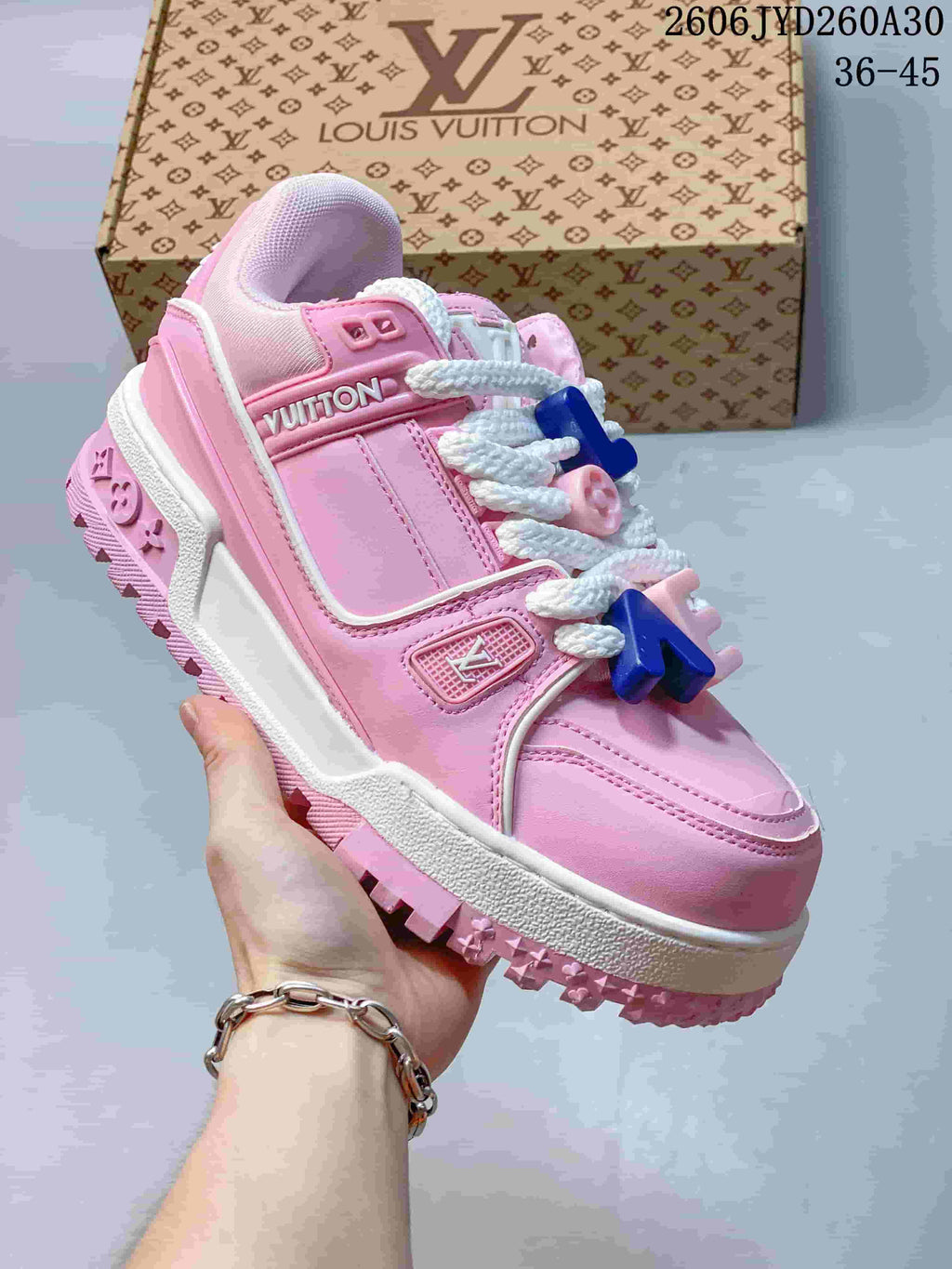 Angled side view of the pink Trainer Maxi sneaker with white laces, logo details and a patterned sole.