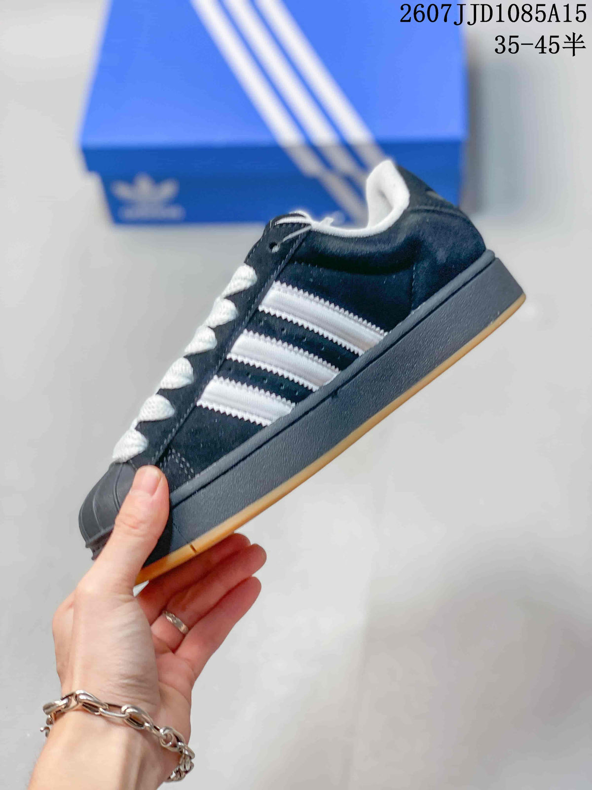 Side view showing the black upper, white three-stripe detailing, raised midsole, and gum outsole.