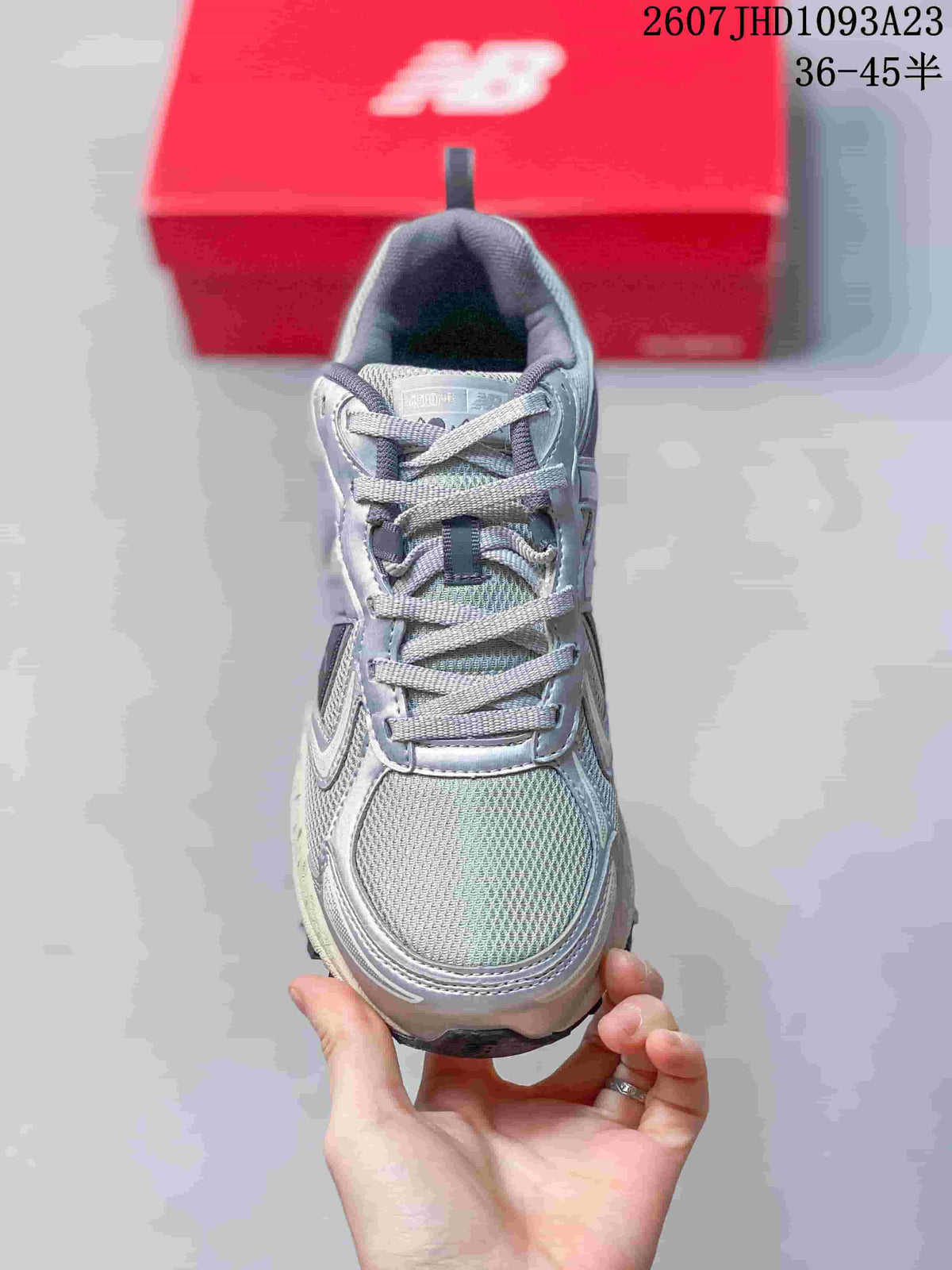 Top view of the grey sneaker showing the mesh toe box, flat laces, tongue, and padded collar.
