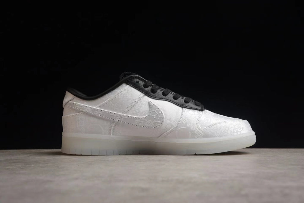 Side profile showing the white patterned upper, black lace trim, and white outsole.