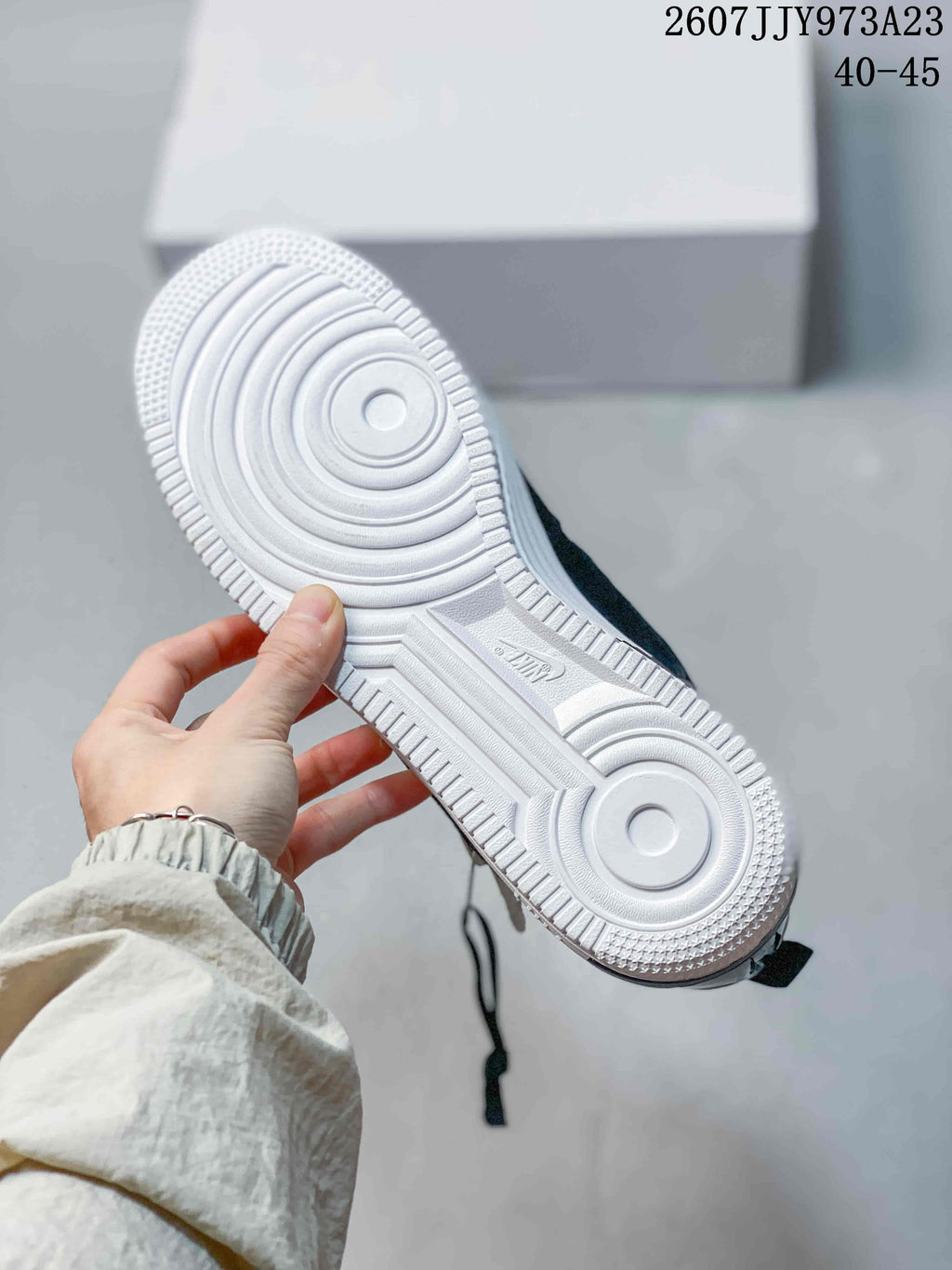 Underside view of the sneaker showing the white circular-patterned outsole and textured perimeter tread; image text shows product code 2607JJY973A23 and size range 40–45.
