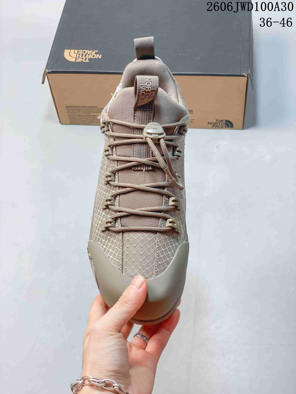 Front view showing cord lacing, toggle closure, and protective toe panel