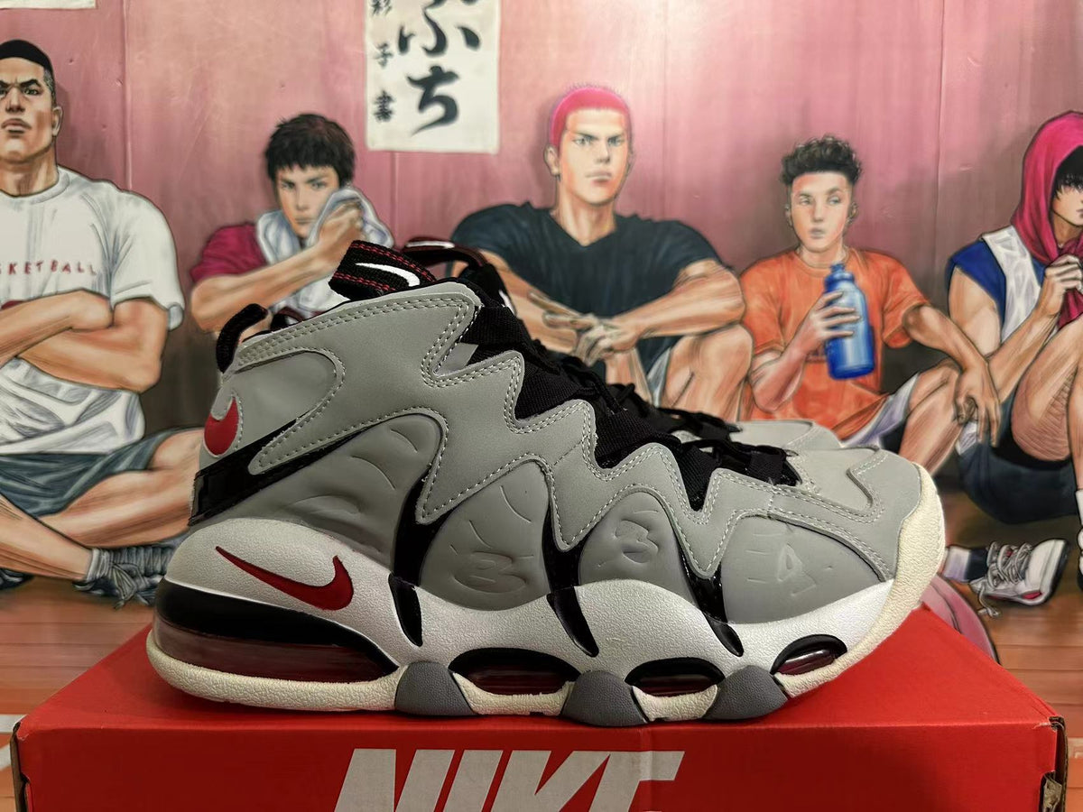 Side view showing the grey sculpted upper, red accents, black detailing, and visible sole cushioning