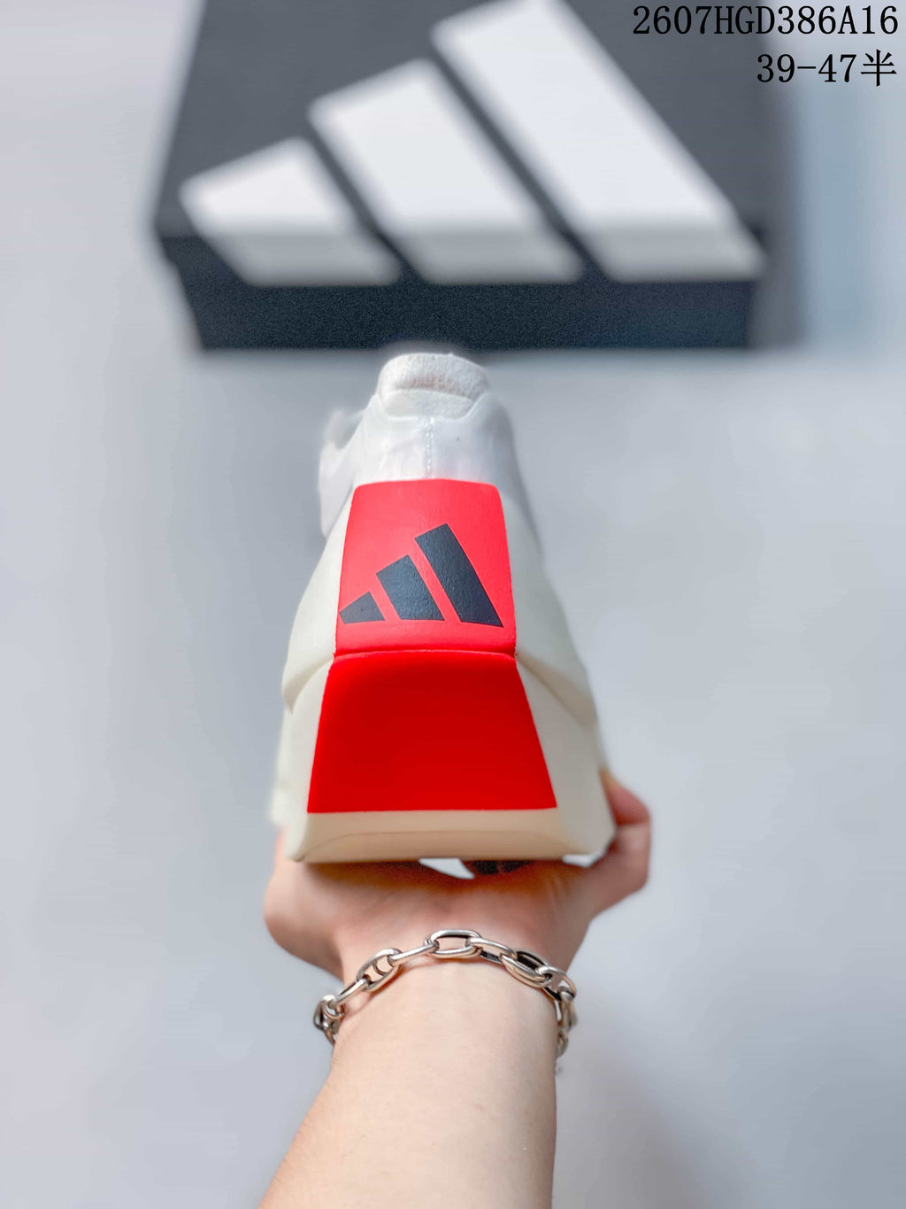 Rear view of the shoe showing the red heel panel and adidas logo.