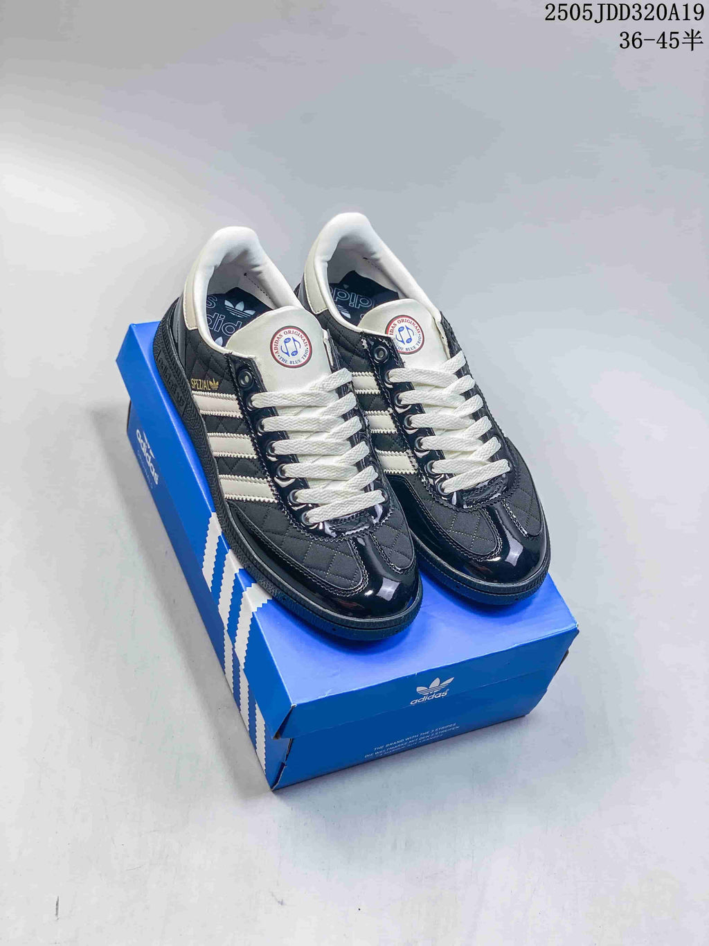 Pair of black and white Adidas Originals low-top sneakers displayed on a blue Adidas shoebox.
