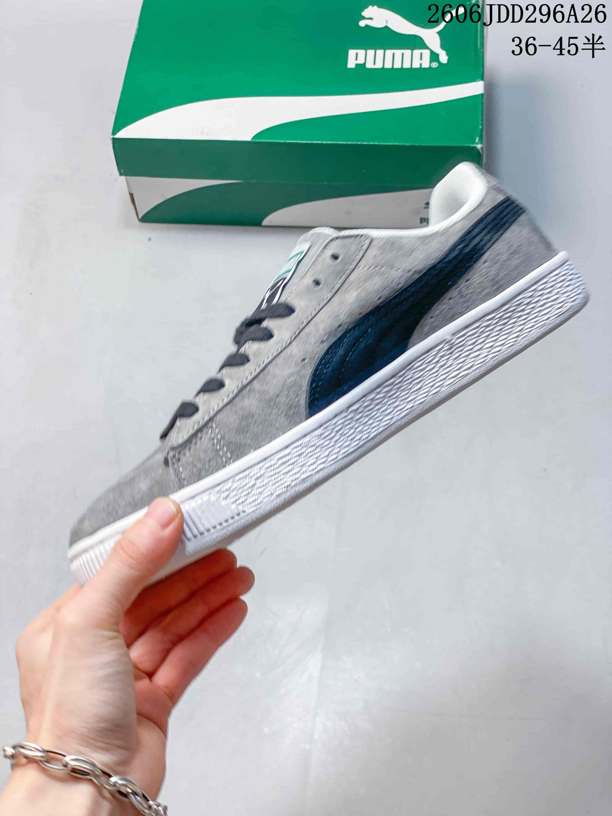 Side profile of a gray low-top Puma sneaker with a dark navy side stripe and white rubber outsole.