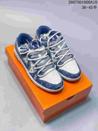 Pair of blue and white low-top sneakers displayed on an orange box, with patterned panels and white laces visible.