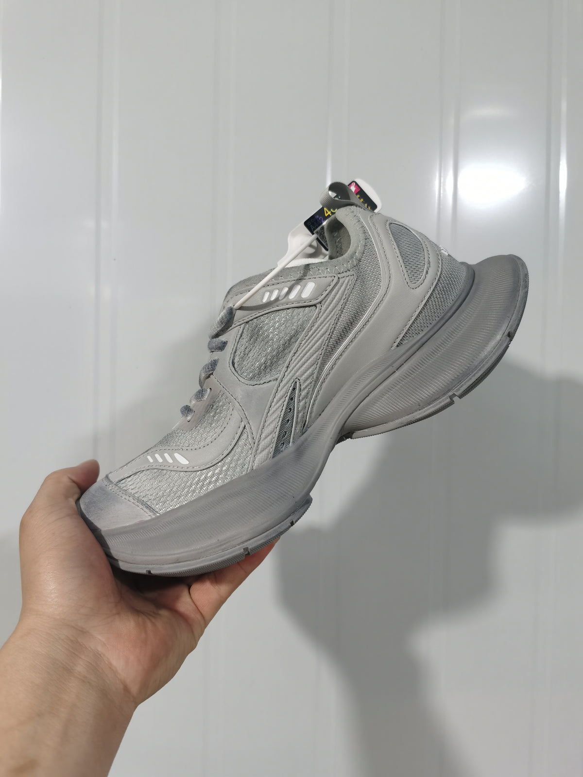 Angled close-up of grey Balenciaga Circuit sneakers showing the layered upper, mesh panels, laces and tonal sole.
