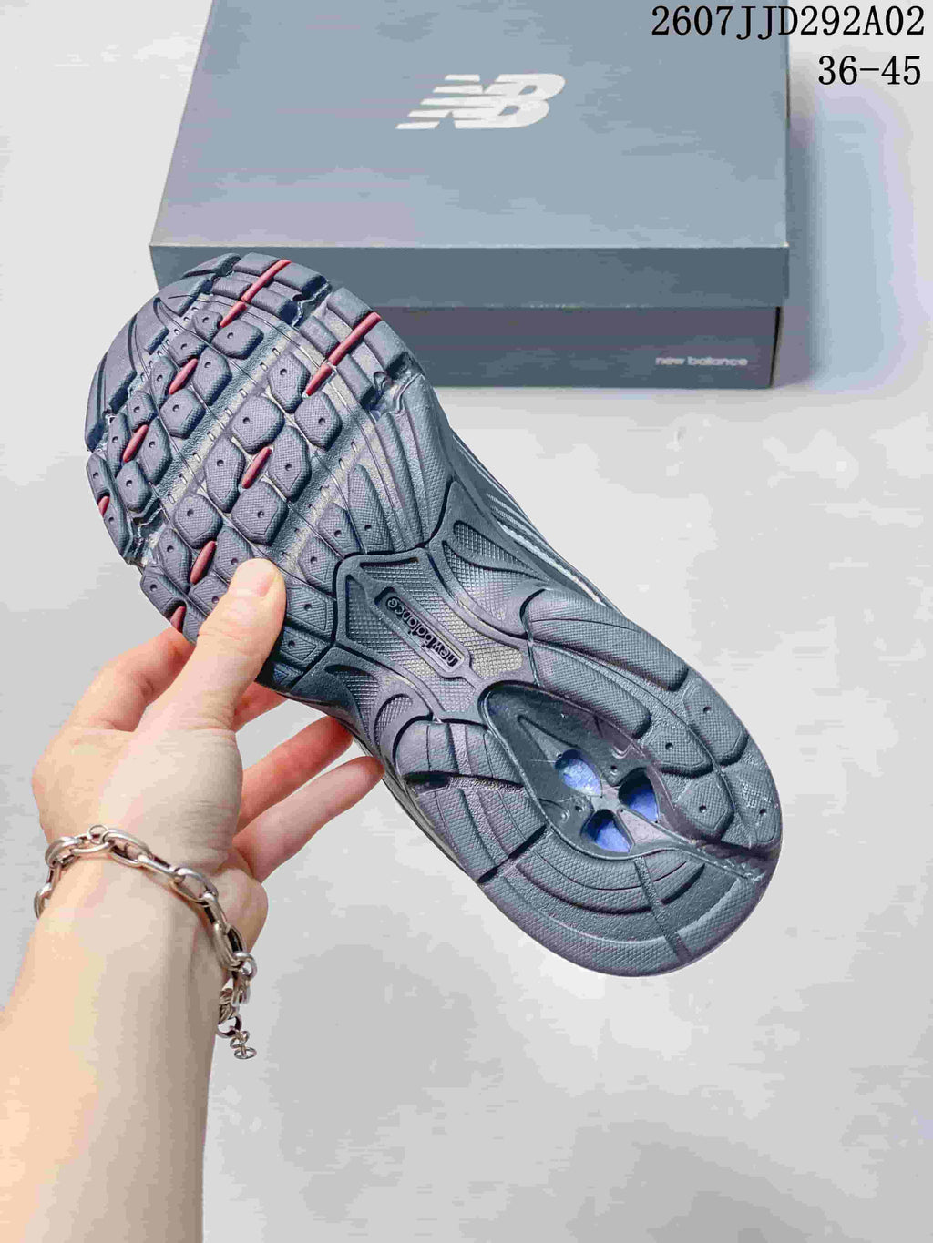 Outsole view showing the segmented tread pattern and contrasting red and blue details.