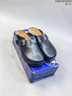 Pair of black buckle clogs displayed on a blue shoebox, with the style code and size range visible at the top right.