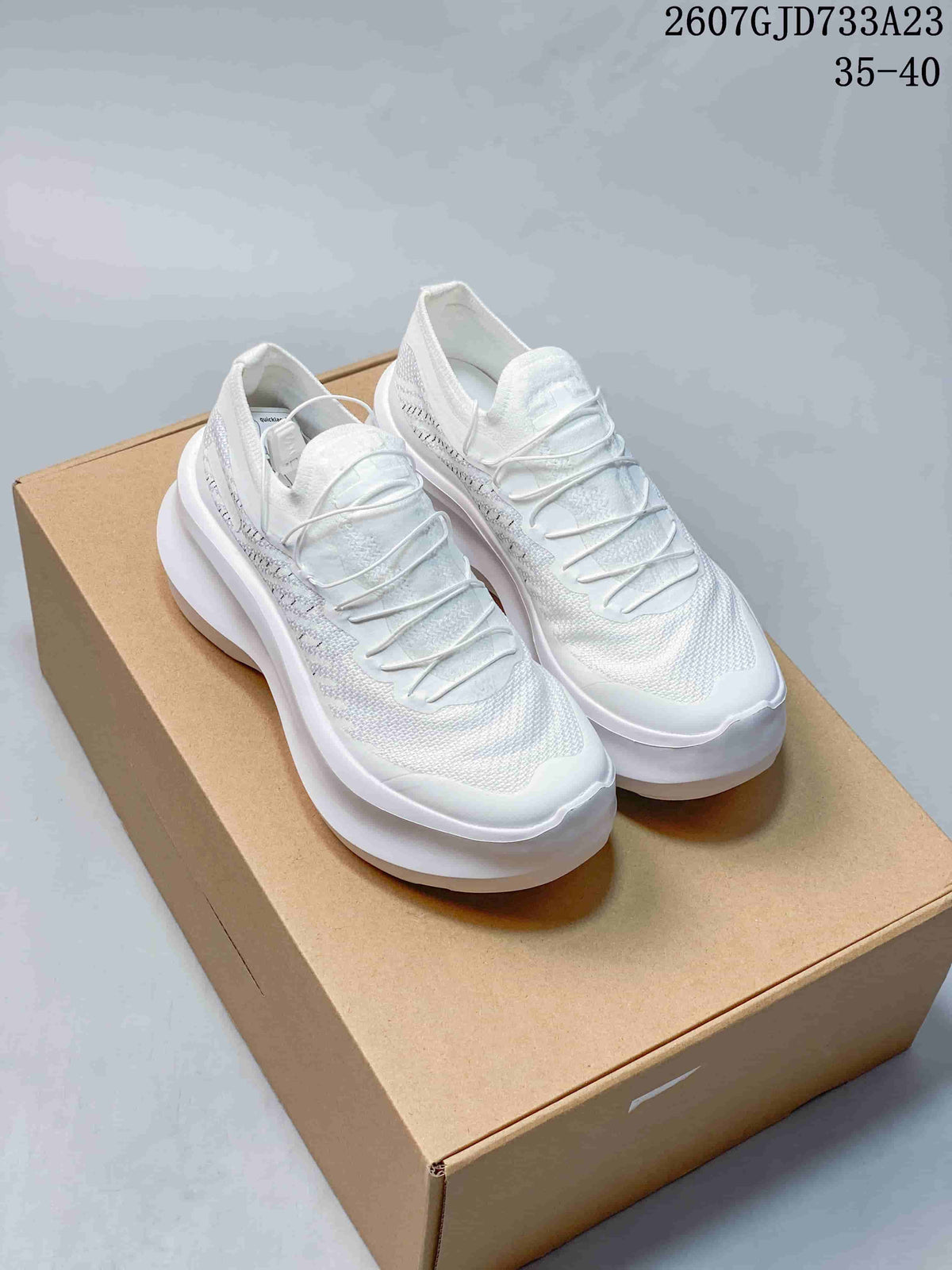 Pair of white Salomon x Comme des Garçons Phantasm 2 sneakers displayed on a box.