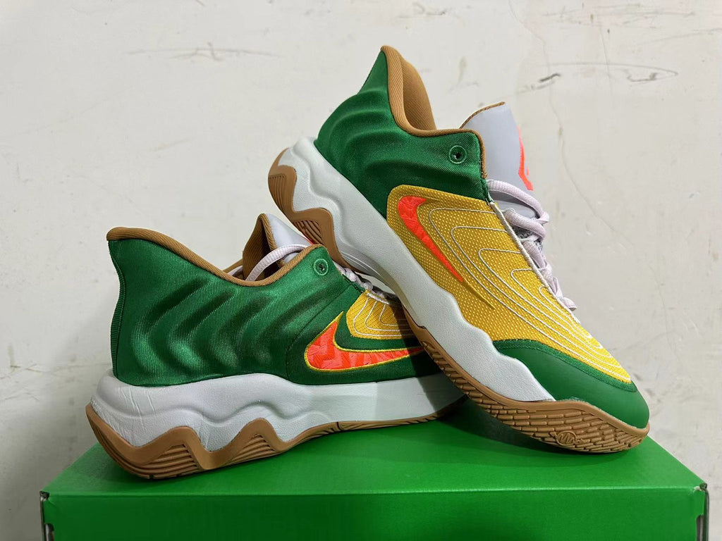 Pair of green and yellow Nike basketball shoes shown at an angle, with orange Swoosh accents and gum outsoles.