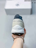 Rear view showing the off-white heel, dark collar, white sole, and Chanel double-C logo.
