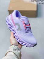 Angled side view of a lavender On Cloudmonster 3 sneaker showing side branding, pink details, textured upper, and segmented sole; image text shows 2607JGD977A27 and 36–40.