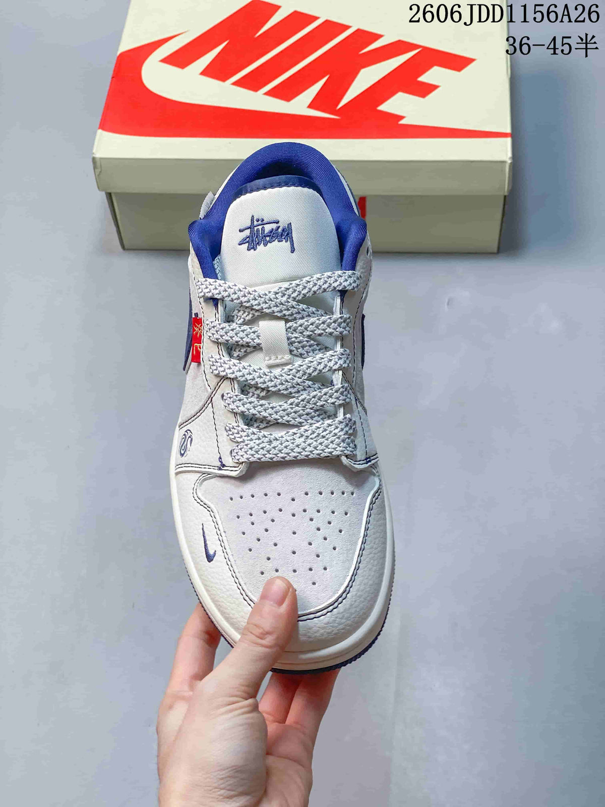 Top view of the sneaker showing the perforated white toe box, patterned laces, blue collar lining, and tongue graphic.
