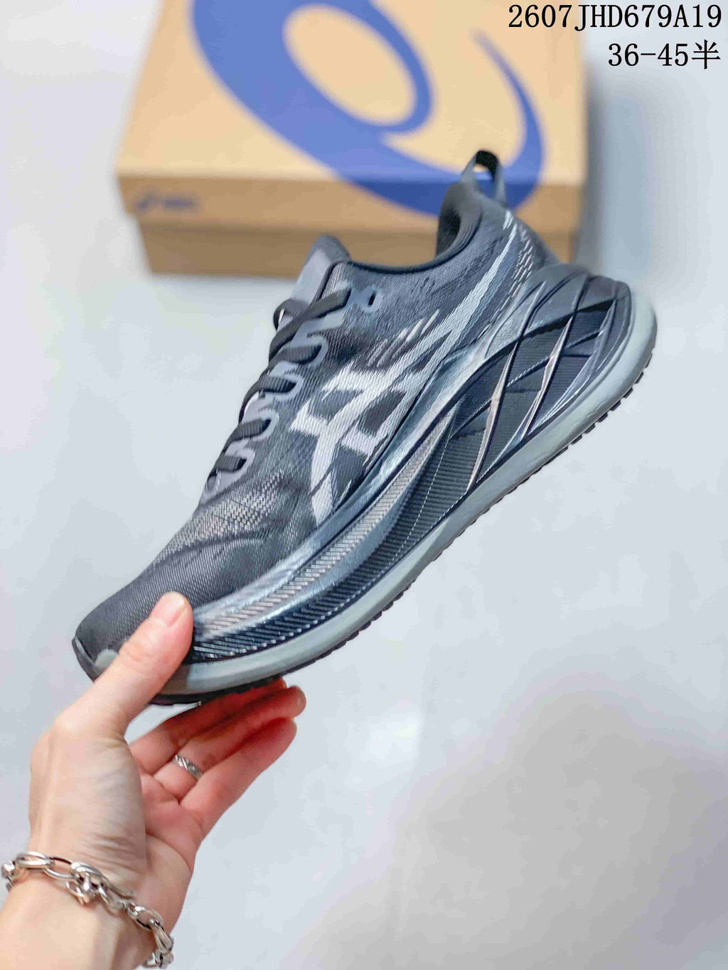 Side profile showing the gray textile upper, ASICS branding, and elevated midsole.