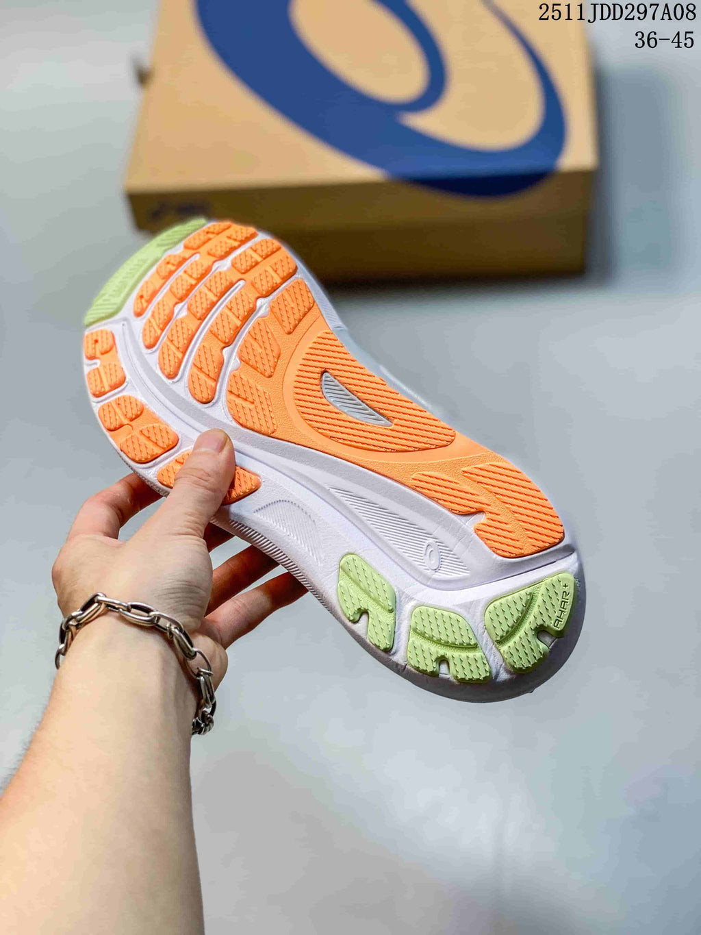 Underside view of the running shoe showing an orange, white and green patterned outsole with textured traction sections.