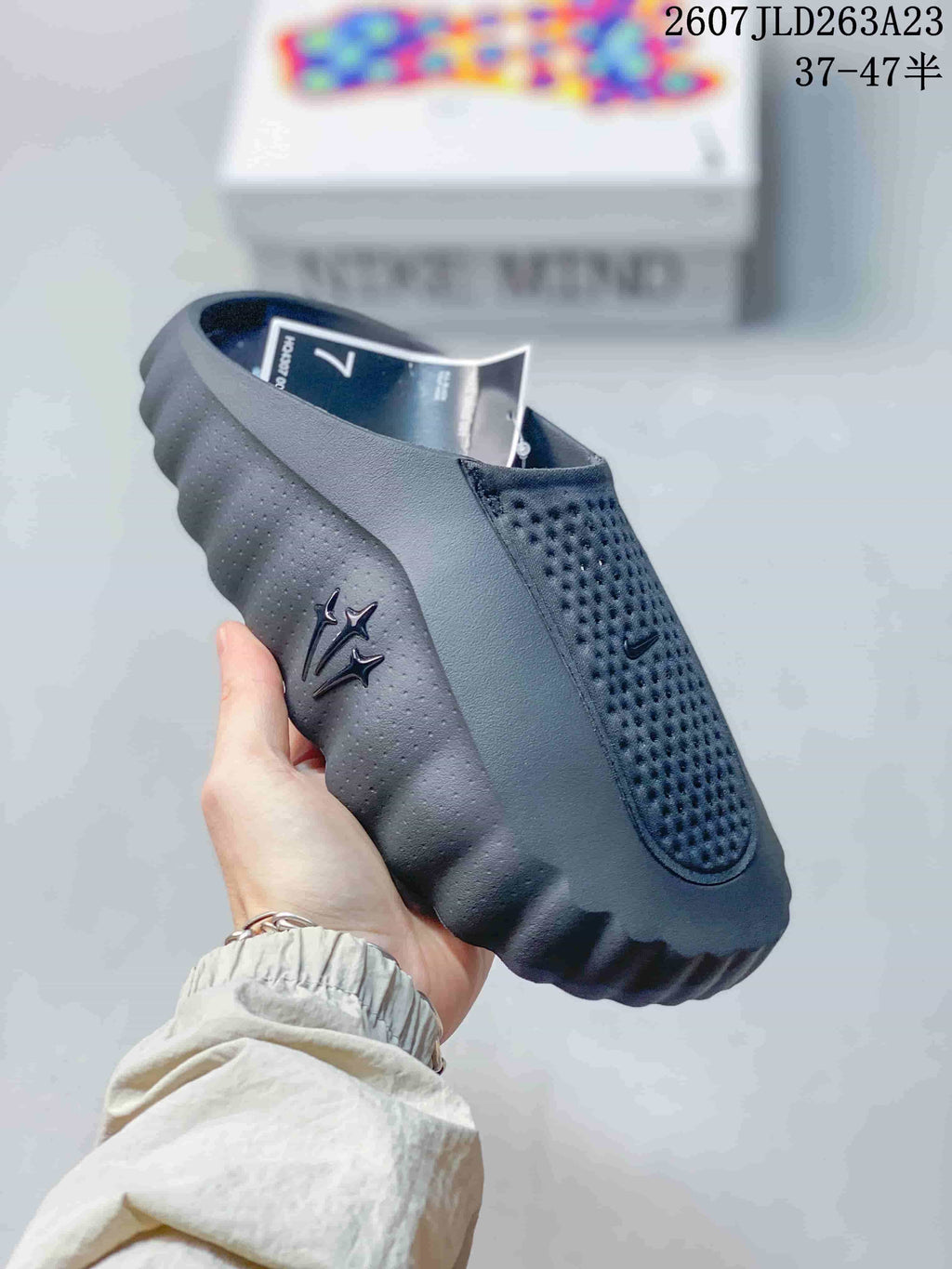 Close-up side view of a black Nike Mind 001 slide with perforated upper, side detailing and a thick sculpted outsole.