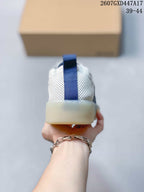 Rear view showing the perforated white heel, blue pull tab, and light-colored outsole.